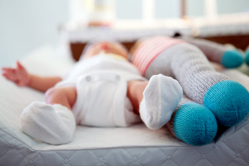 A cute photo of newborn Everett laying on his changing pad with his stuffed puppy.