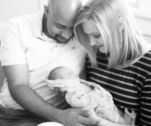 New parents, Cara and Vic, admiring their new baby with Down syndrome