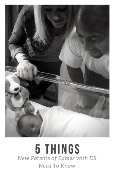 A photo of Cara and Victor learning over Everett's bassinet in the hospital, admiring him